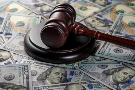 Wooden judge gavel, soundboard with US 100 dollar bills on the background, close up. Finance and justice concept